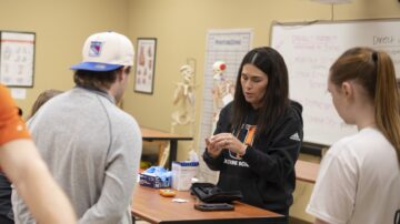 Professor works with students in lab